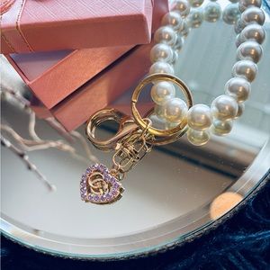Luxury charm attached to unbranded pearl wristlet